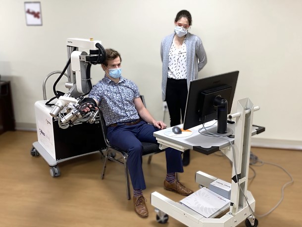 Scientist observing research participant use a therapeutic gaming robot